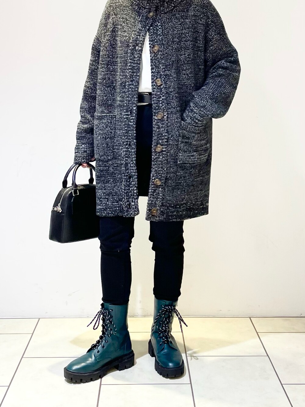 ブラック系のデニムパンツ、グリーン系のブーツ、ブラック系のショルダーバッグを着用したレディースの冬コーディネートの4枚目の写真