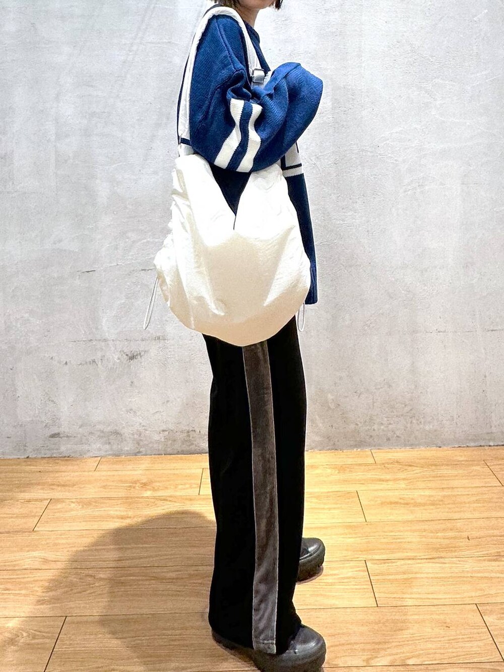 ホワイト系のショルダーバッグ、ブラック系のその他パンツ、ブルー系のニット/セーターを着用したレディースの秋コーディネートの7枚目の写真