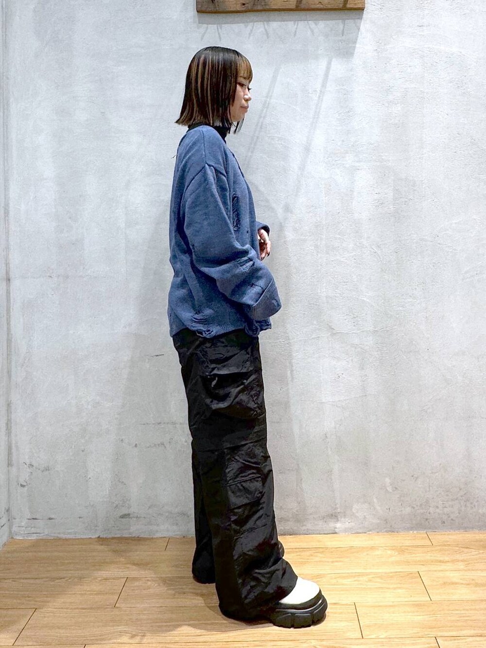 ブルー系のニット/セーター、ホワイト系のブーツ、ブラック系のカーゴパンツを着用したレディースの冬コーディネートの3枚目の写真