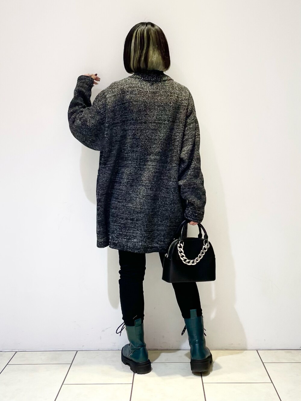 ブラック系のデニムパンツ、グリーン系のブーツ、ブラック系のショルダーバッグを着用したレディースの冬コーディネートの3枚目の写真