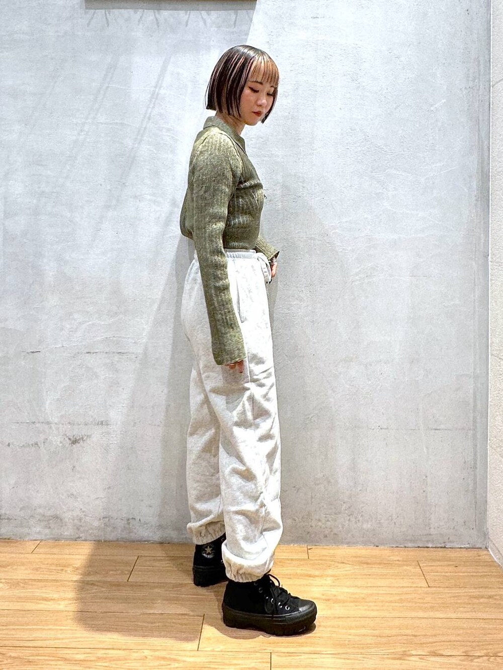 グレー系のスウェットパンツ、グリーン系のニット/セーターを着用したレディースの秋コーディネートの4枚目の写真