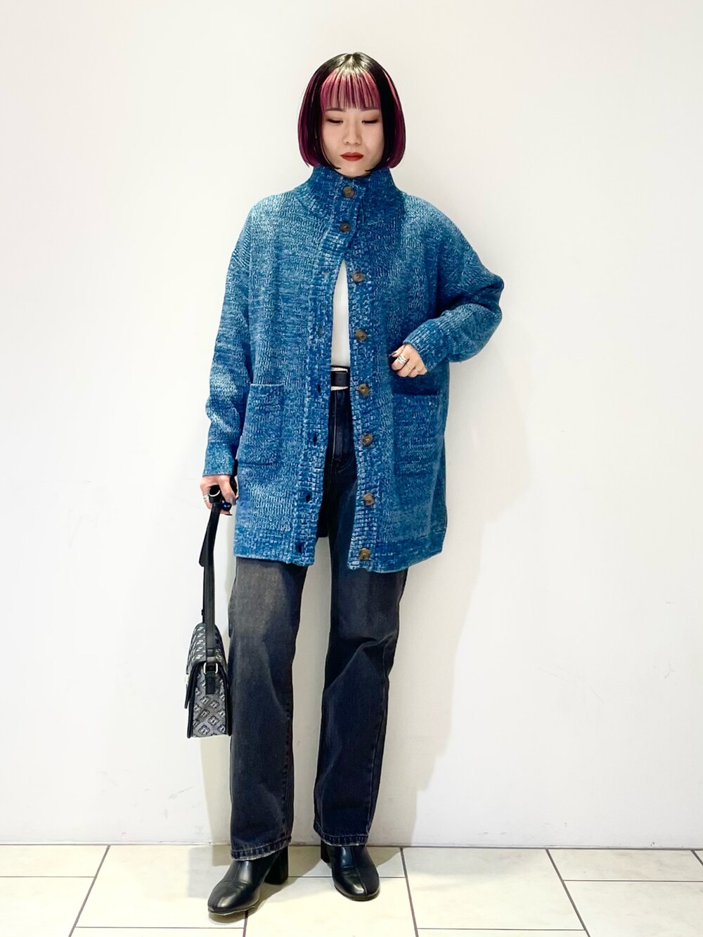 ホワイト系のニット/セーター、グリーン系のニット/セーター、ブラック系のデニムパンツを着用したレディースの冬コーディネートの2枚目の写真