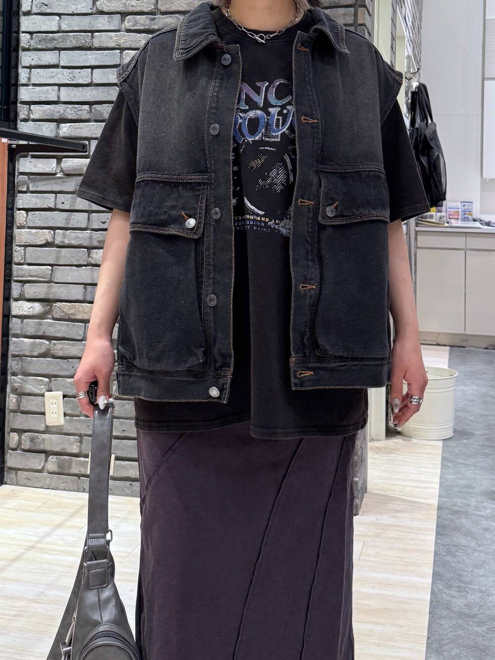 グレー系のサンダル、グレー系のショルダーバッグ、ブラック系のデニムジャケットを着用したレディースの春コーディネートの5枚目の写真