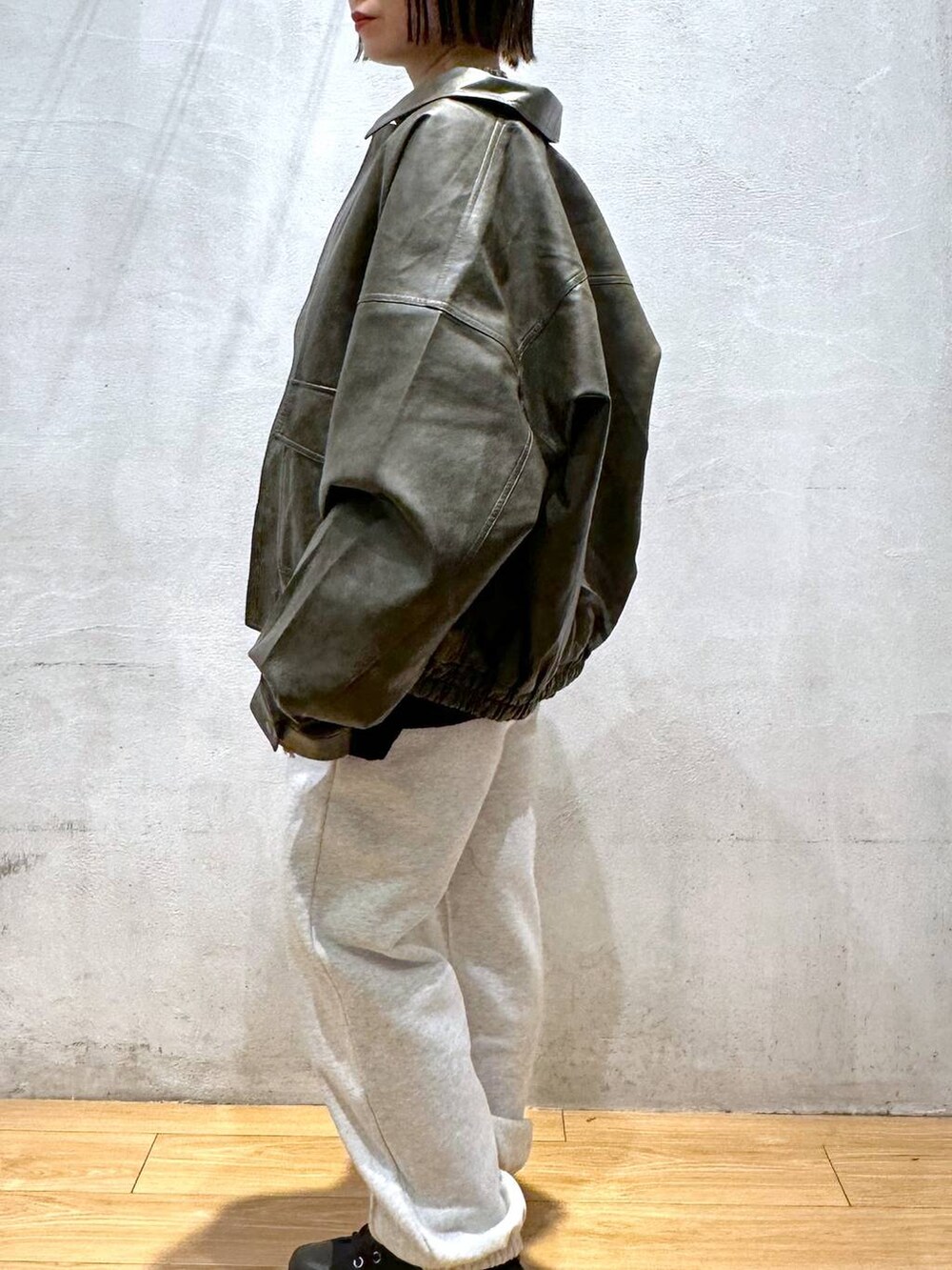 ブラウン系のブルゾン、グレー系のスウェットパンツ、ブラック系のニット/セーターを着用したレディースの秋コーディネートの8枚目の写真