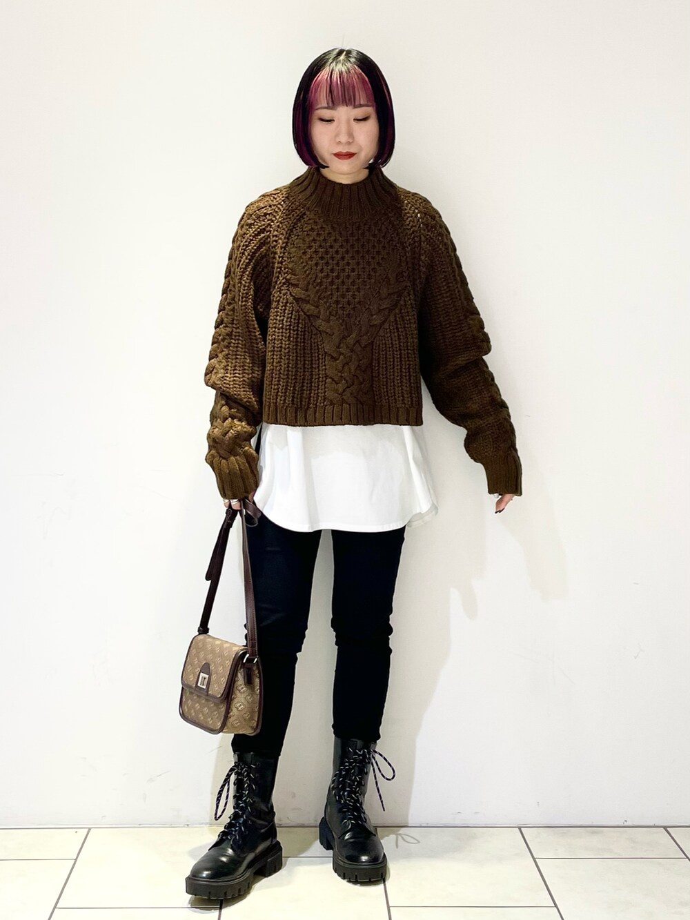 ブラック系のブルゾン、ホワイト系のTシャツ/カットソー、ブラウン系のニット/セーターを着用したレディースの冬コーディネートの4枚目の写真