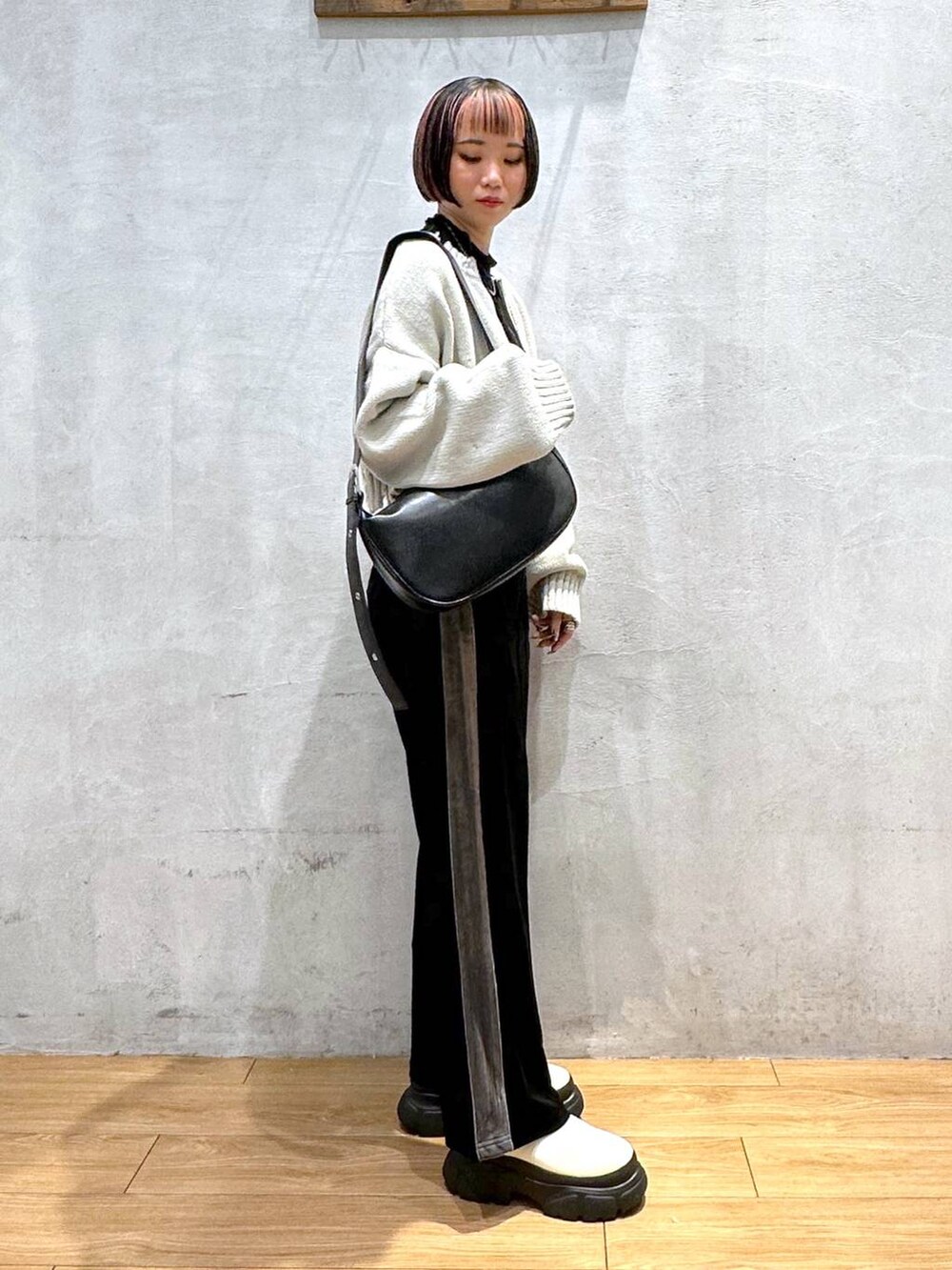 ホワイト系のブーツ、ブラック系のショルダーバッグ、ブラック系のその他パンツを着用したレディースの秋コーディネートの3枚目の写真