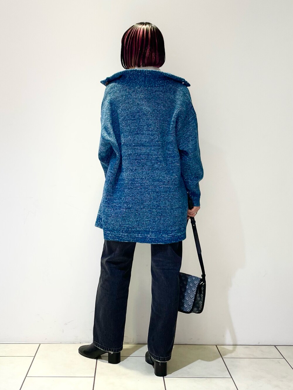 ホワイト系のニット/セーター、グリーン系のニット/セーター、ブラック系のデニムパンツを着用したレディースの冬コーディネートの3枚目の写真