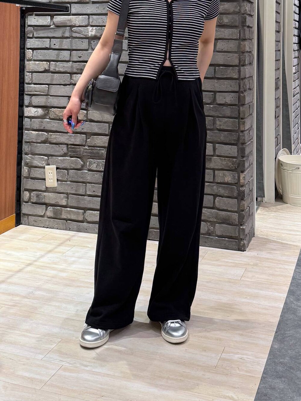 ブラック系のショルダーバッグ、ブラック系のTシャツ/カットソー、ブラック系のスウェットパンツを着用したレディースの春コーディネートの3枚目の写真