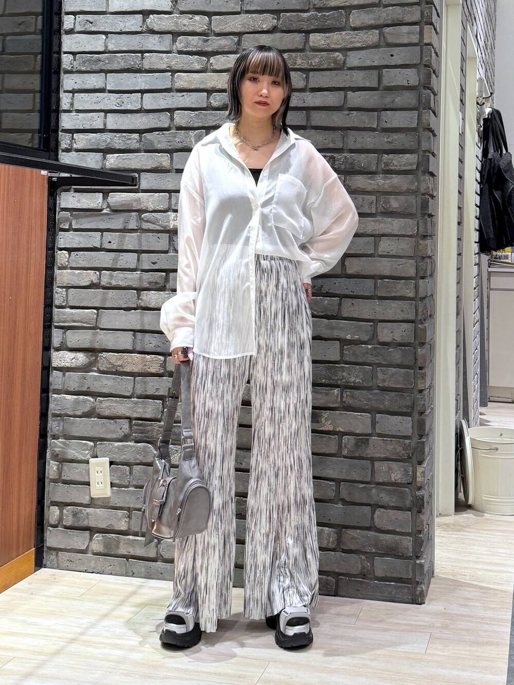 グレー系のサンダル、グレー系のショルダーバッグ、ブラック系のタンクトップを着用したレディースの春コーディネートの2枚目の写真