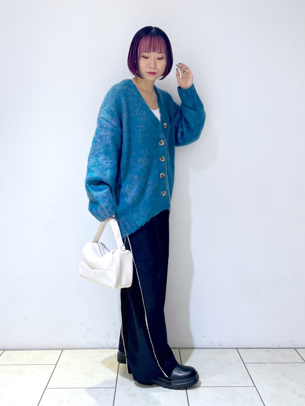 ブルー系のカーディガン/ボレロ、ホワイト系のキャミソール、ブラック系のスラックスを着用したレディースの秋コーディネートの3枚目の写真