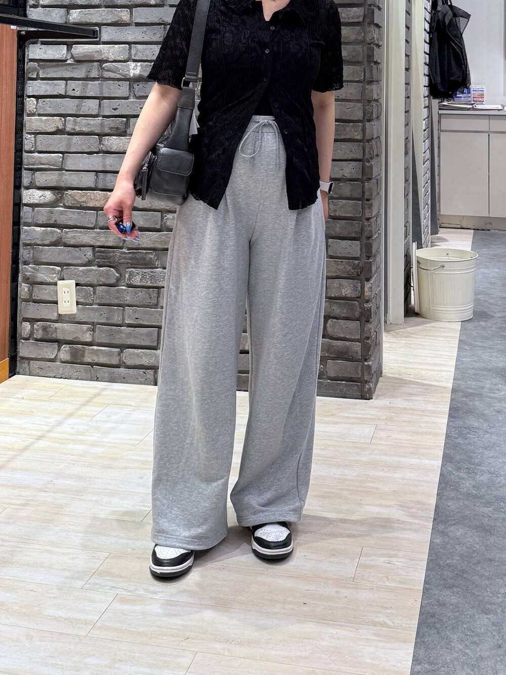 ブラック系のショルダーバッグ、ブラック系のシャツ/ブラウス、グレー系のスウェットパンツを着用したレディースの春コーディネートの5枚目の写真