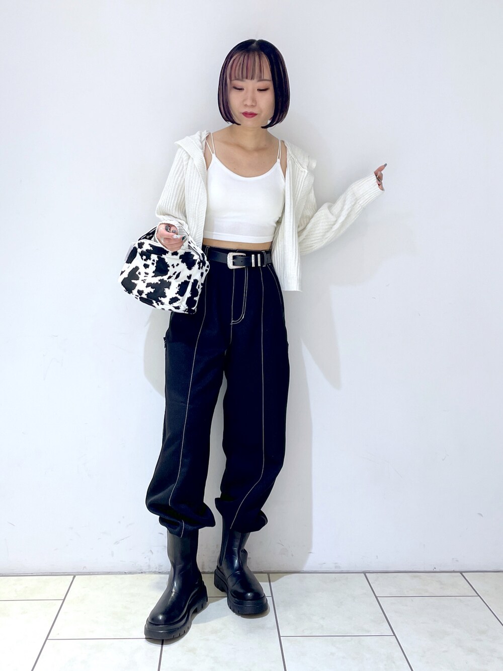 ホワイト系のキャミソール、ブラック系のハンドバッグ、ブラック系のその他パンツを着用したレディースの秋コーディネートの2枚目の写真