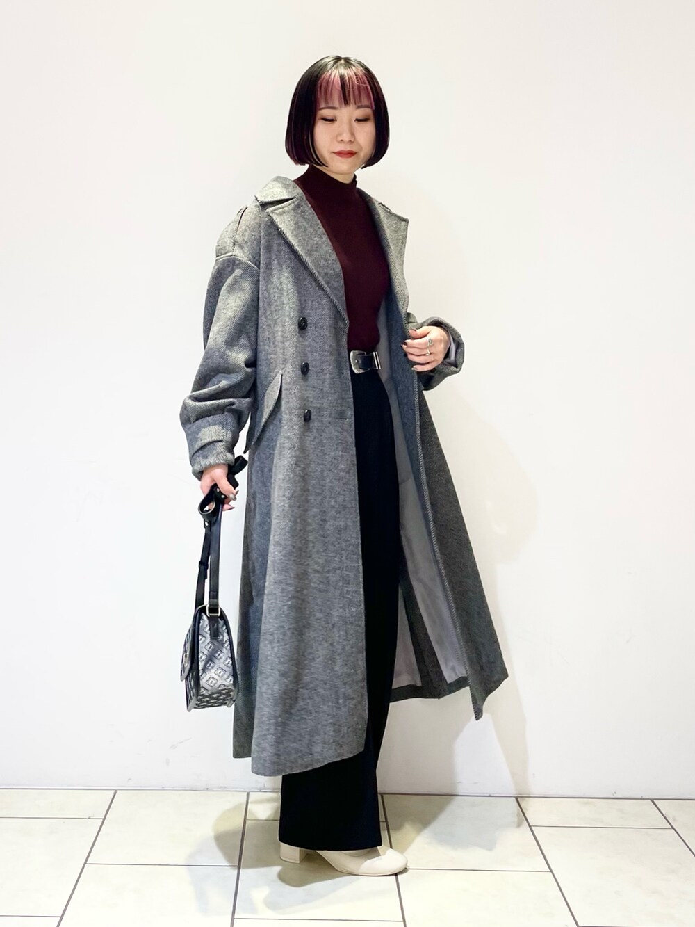 ブラウン系のニット/セーター、ブラック系のその他アウター、ブラック系のスラックスを着用したレディースの冬コーディネートの2枚目の写真