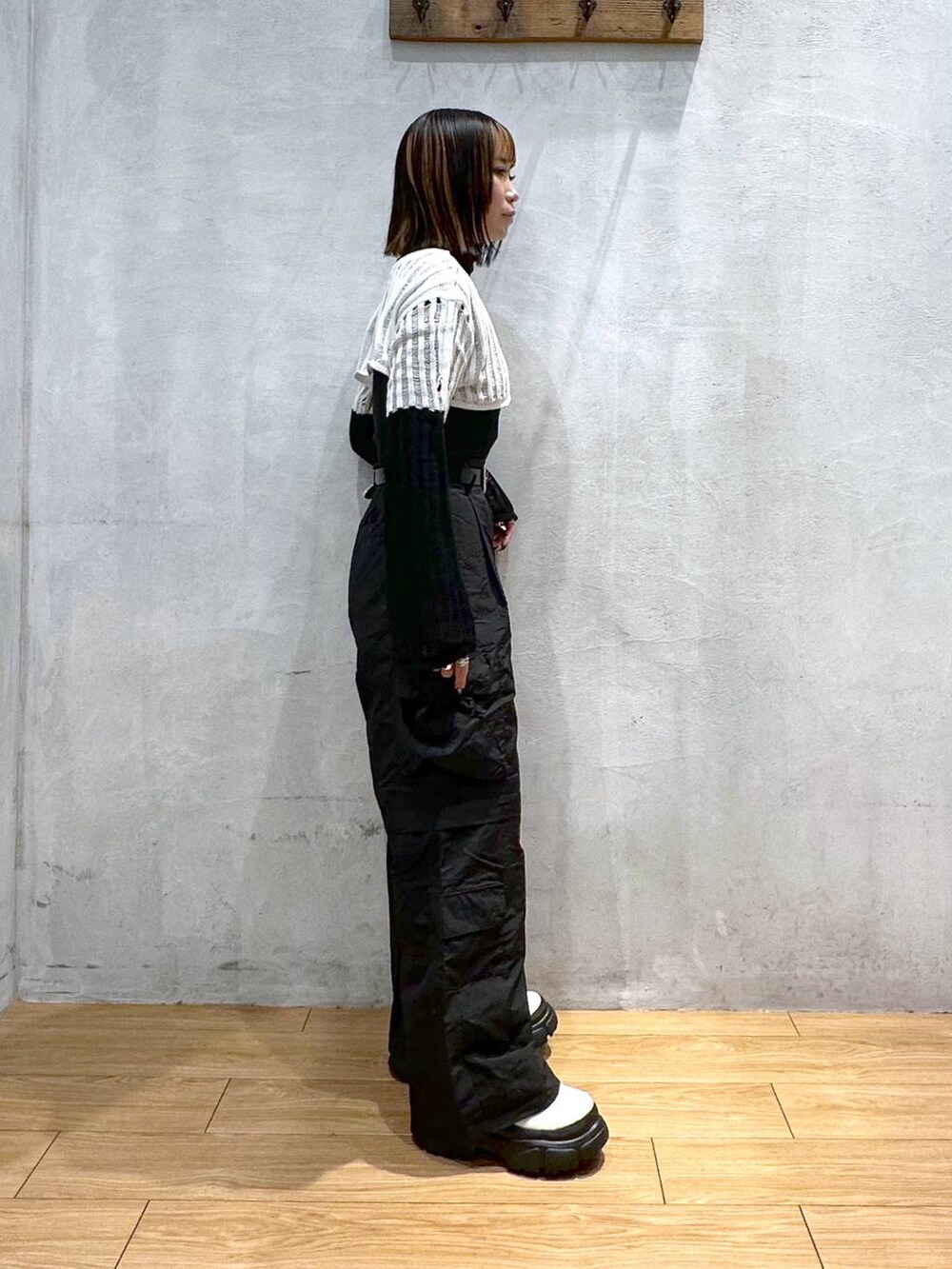 ホワイト系のニット/セーター、ブラック系のカーゴパンツ、ホワイト系のブーツを着用したレディースの冬コーディネートの3枚目の写真