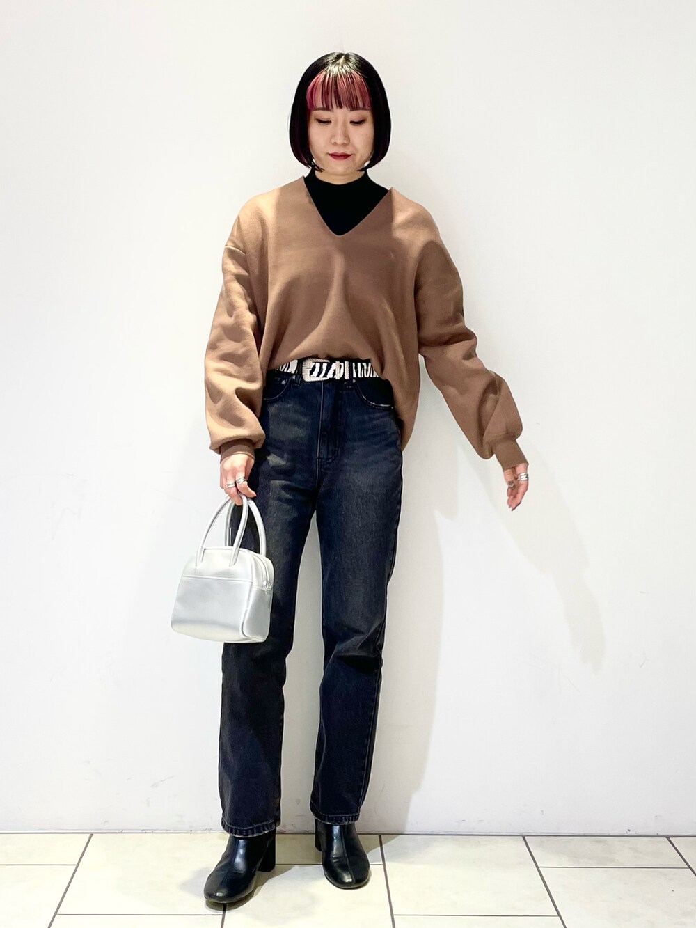 ブラウン系のニット/セーター、ブラック系のニット/セーター、ブラック系のデニムパンツを着用したレディースの春コーディネートの2枚目の写真