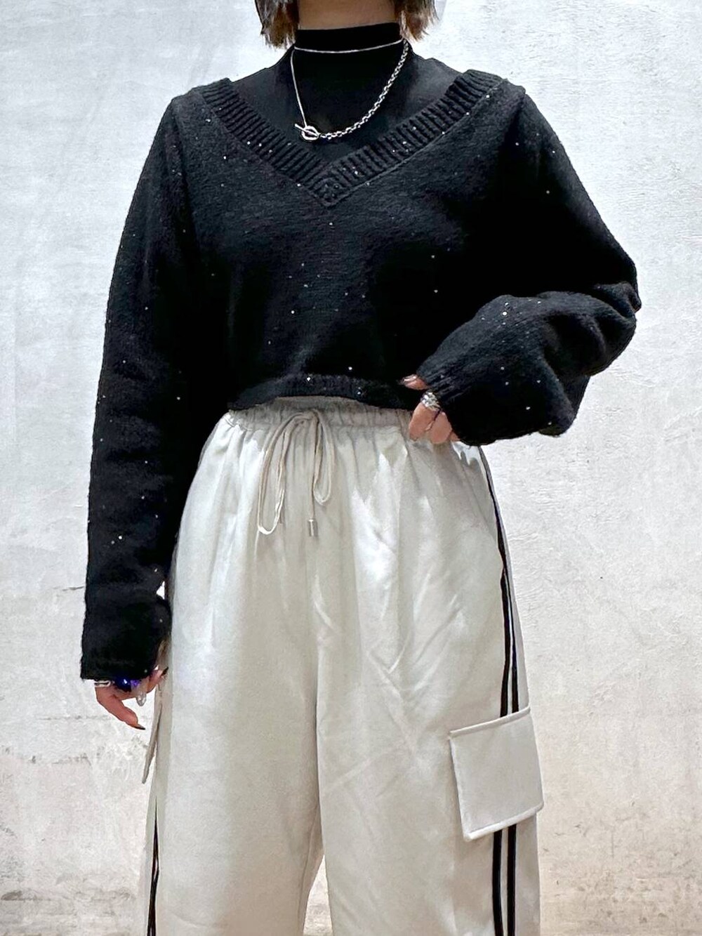 ベージュ系のその他パンツ、ブラック系のTシャツ/カットソー、ブラック系のニット/セーターを着用したレディースの冬コーディネートの5枚目の写真