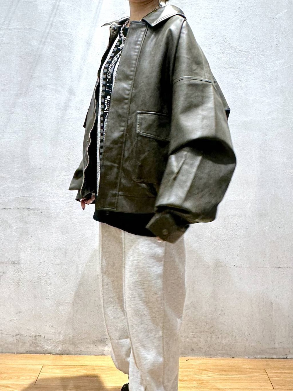 ブラウン系のブルゾン、グレー系のスウェットパンツ、ブラック系のニット/セーターを着用したレディースの秋コーディネートの7枚目の写真