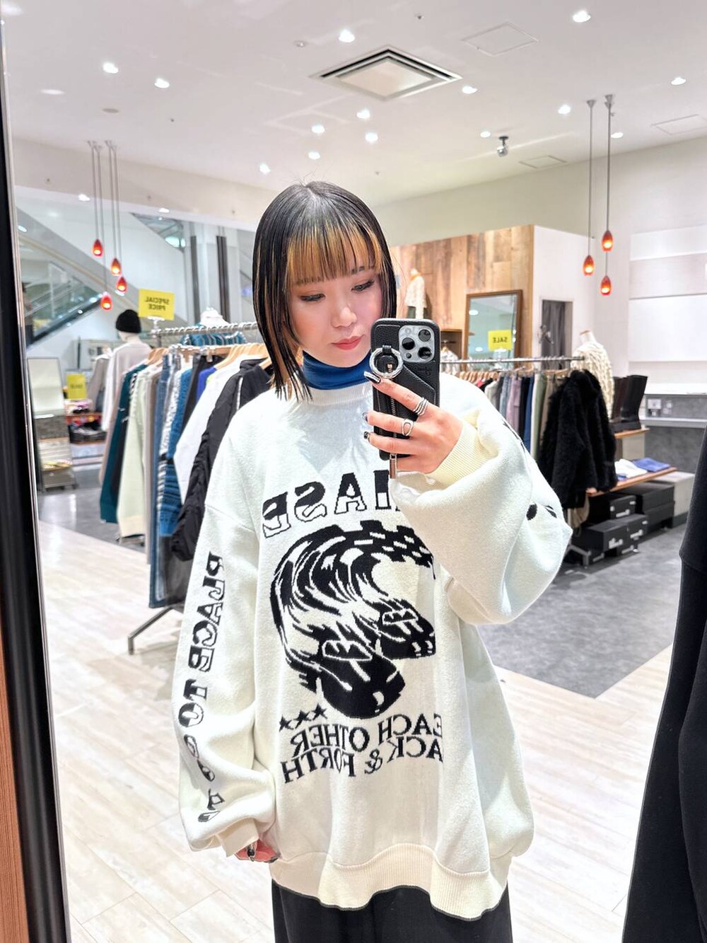 ブラック系のスラックス、ホワイト系のニット/セーターを着用したレディースの冬コーディネートの2枚目の写真