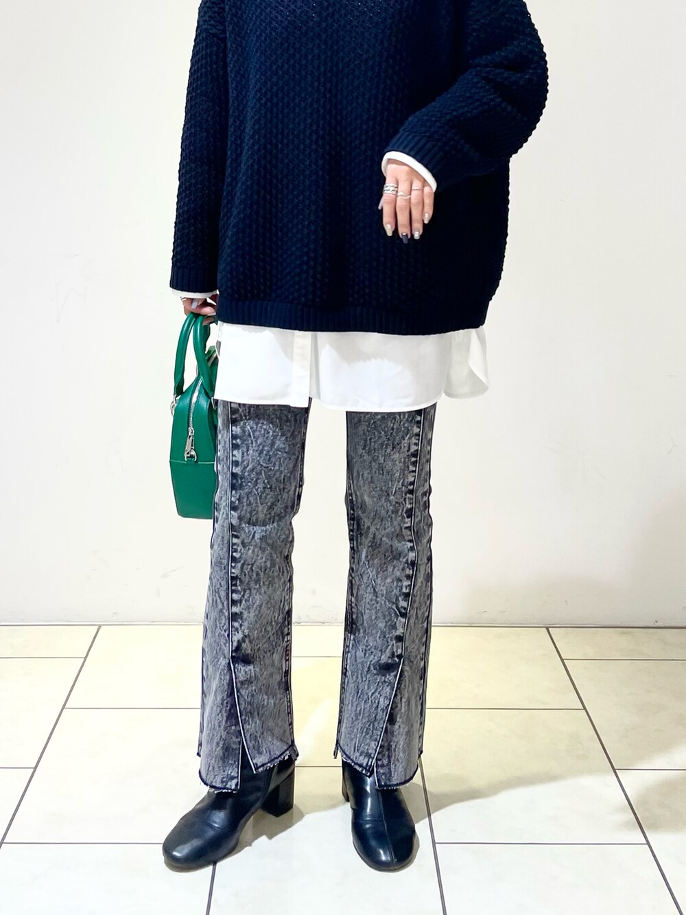 ホワイト系のシャツ/ブラウス、ブラック系のニット/セーター、グリーン系のショルダーバッグを着用したレディースの春コーディネートの5枚目の写真