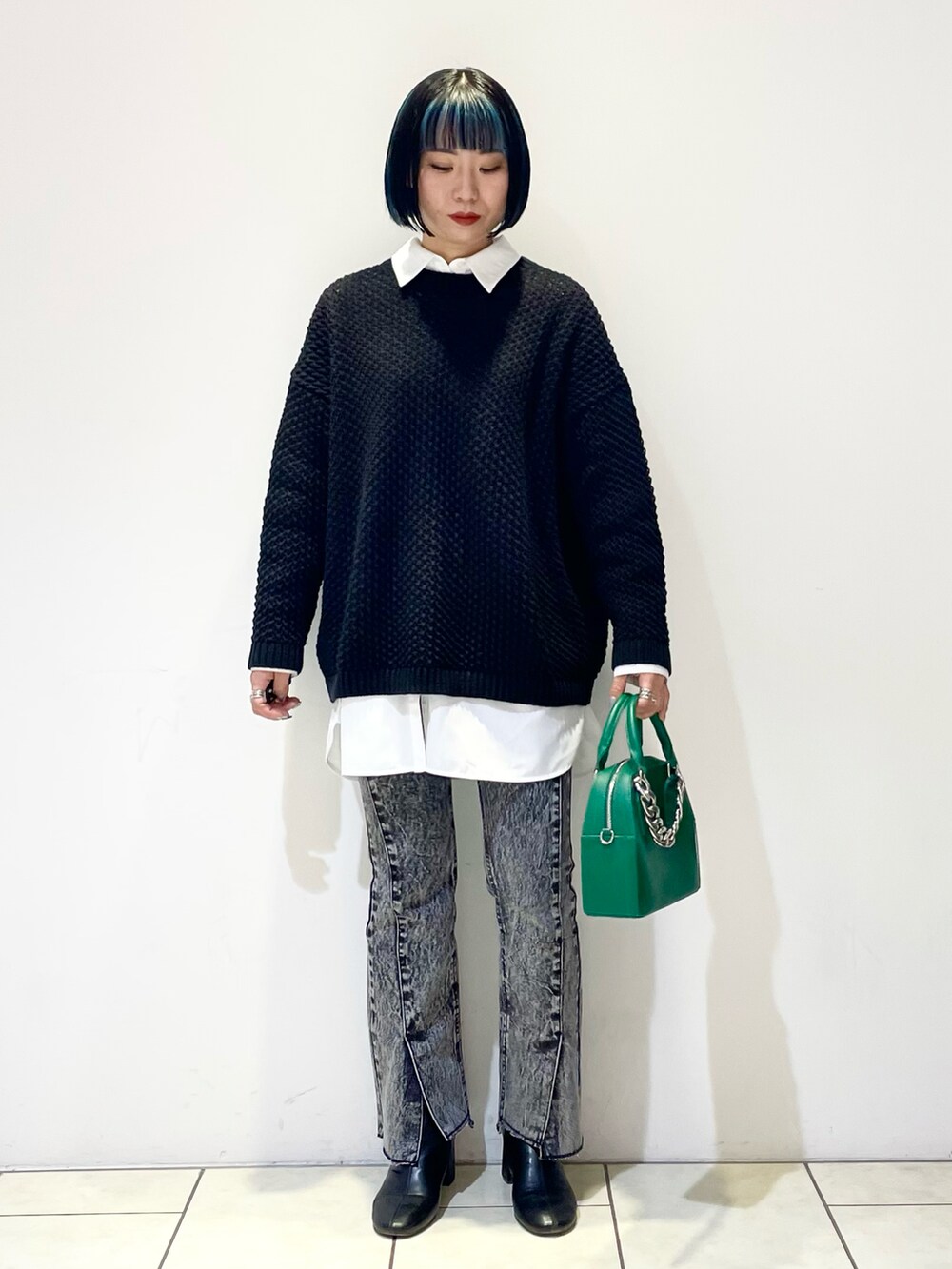 ホワイト系のシャツ/ブラウス、ブラック系のニット/セーター、グリーン系のショルダーバッグを着用したレディースの春コーディネートの3枚目の写真