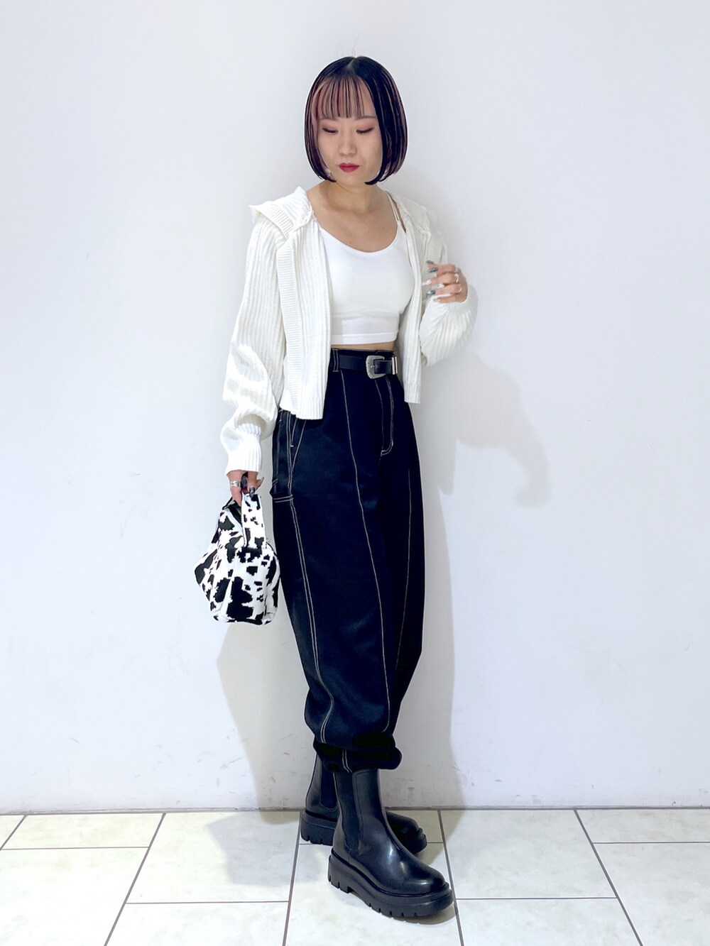 ホワイト系のキャミソール、ブラック系のハンドバッグ、ブラック系のその他パンツを着用したレディースの秋コーディネートの4枚目の写真