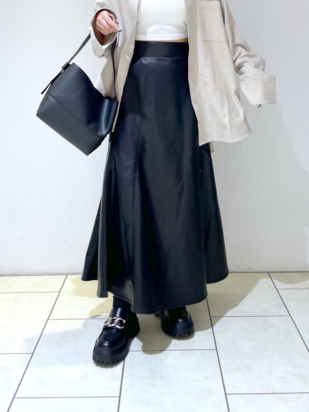 ホワイト系のキャミソール、ホワイト系のシャツ/ブラウス、ブラック系のショルダーバッグを着用したレディースの秋コーディネートの5枚目の写真