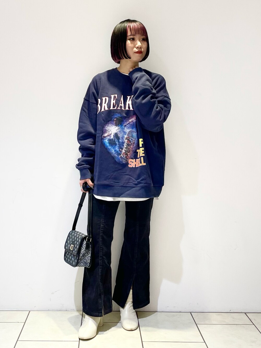 ブルー系のトップス、ホワイト系のTシャツ/カットソー、ブラック系のショルダーバッグを着用したレディースの冬コーディネートの2枚目の写真