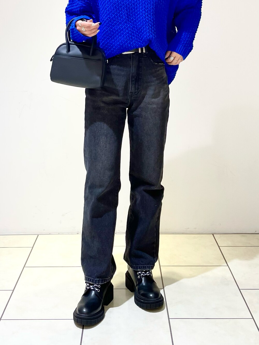 ブラック系のニット/セーター、ブルー系のニット/セーター、ブラック系のボストンバッグを着用したレディースの春コーディネートの5枚目の写真