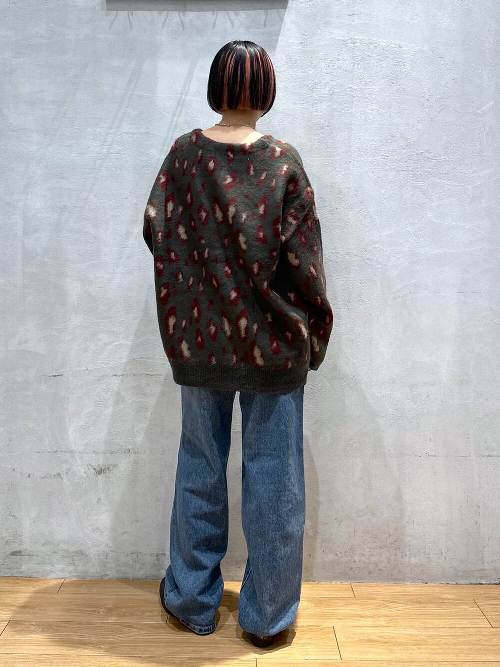 レッド系のカーディガン/ボレロ、ブルー系のデニムパンツ、シルバー系のネックレスを着用したレディースの秋コーディネートの5枚目の写真