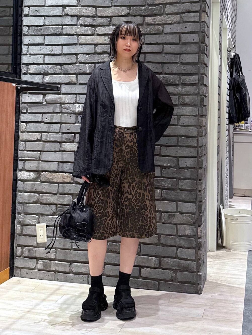 ブラック系のサンダル、ホワイト系のタンクトップ、ブラック系のボディバッグ/ウエストポーチを着用したレディースの春コーディネートの2枚目の写真