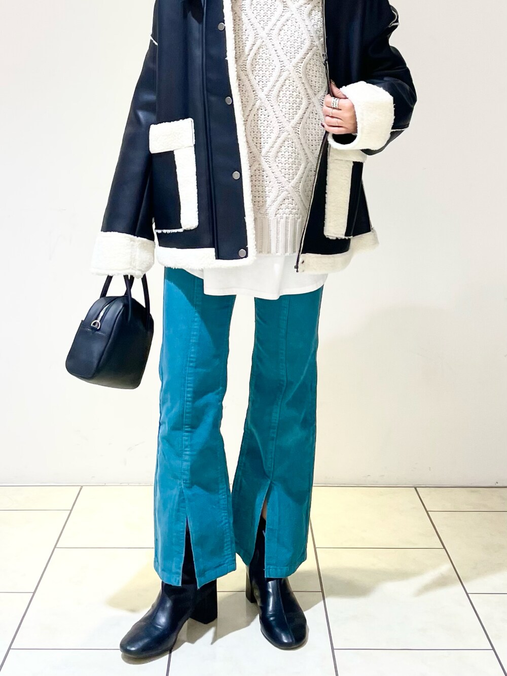 ブラック系のブルゾン、ベージュ系のニット/セーター、ホワイト系のTシャツ/カットソーを着用したレディースの冬コーディネートの4枚目の写真