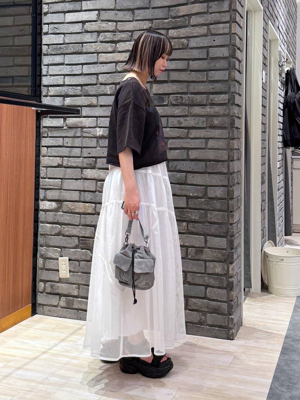 ブラック系のサンダル、ベージュ系のショルダーバッグ、グレー系のTシャツ/カットソーを着用したレディースの春コーディネートの3枚目の写真