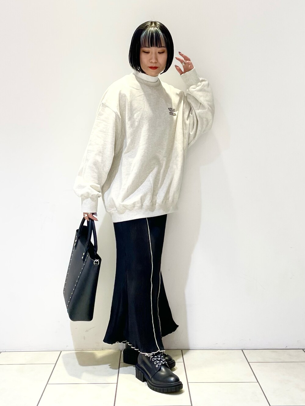 ホワイト系のニット/セーター、ベージュ系のスウェット、ブラック系のショルダーバッグを着用したレディースの春コーディネートの4枚目の写真