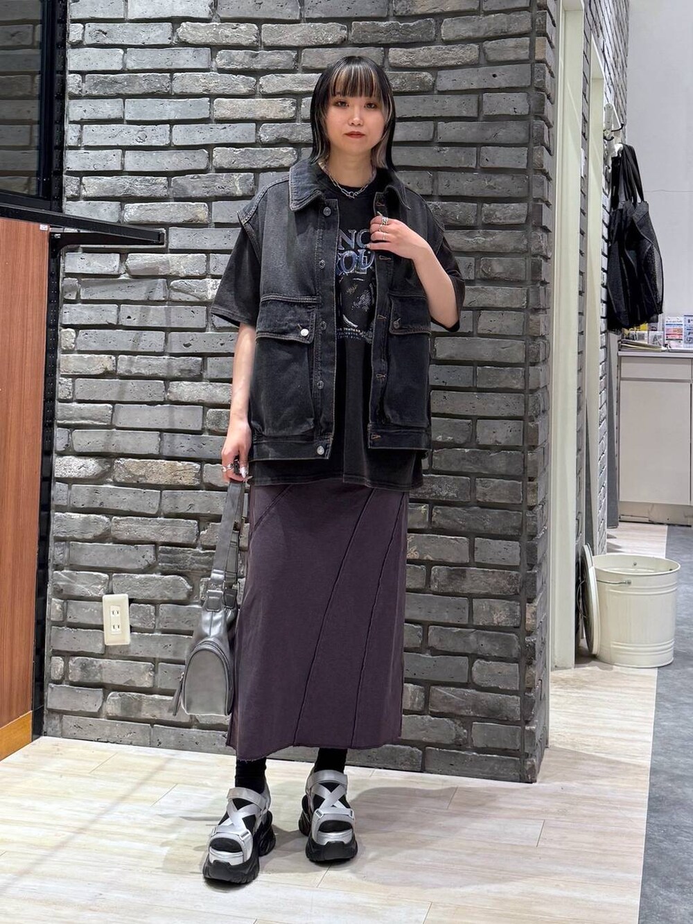 グレー系のサンダル、グレー系のショルダーバッグ、ブラック系のデニムジャケットを着用したレディースの春コーディネートの2枚目の写真