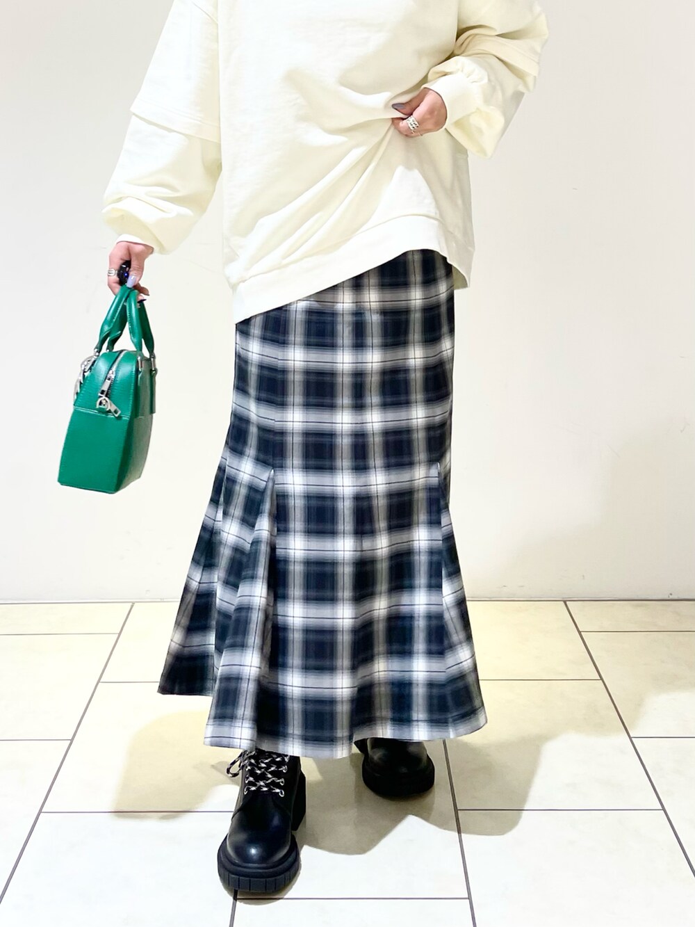 ホワイト系のスウェット、ブラック系のニット/セーター、グリーン系のショルダーバッグを着用したレディースの春コーディネートの5枚目の写真