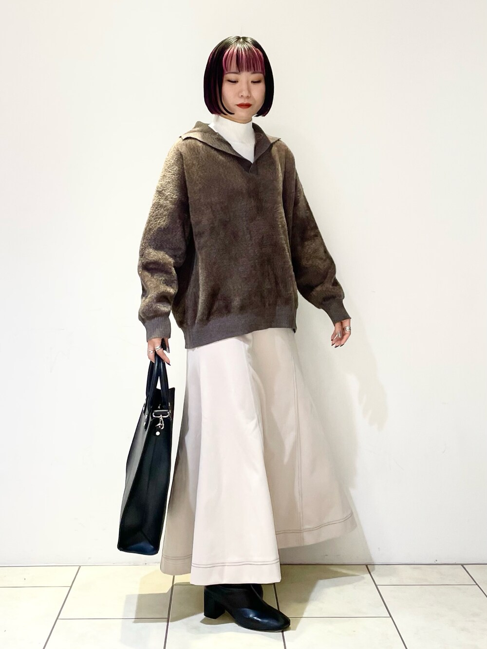 ホワイト系のニット/セーター、ブラウン系のニット/セーター、ブラック系のトートバッグを着用したレディースの冬コーディネートの2枚目の写真