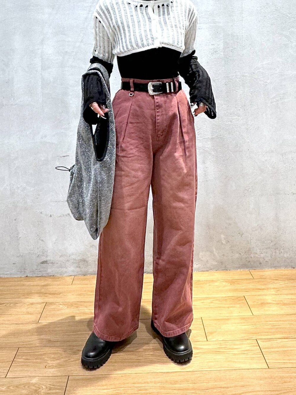ブラック系のトートバッグ、レッド系のデニムパンツ、ホワイト系のニット/セーターを着用したレディースの冬コーディネートの3枚目の写真