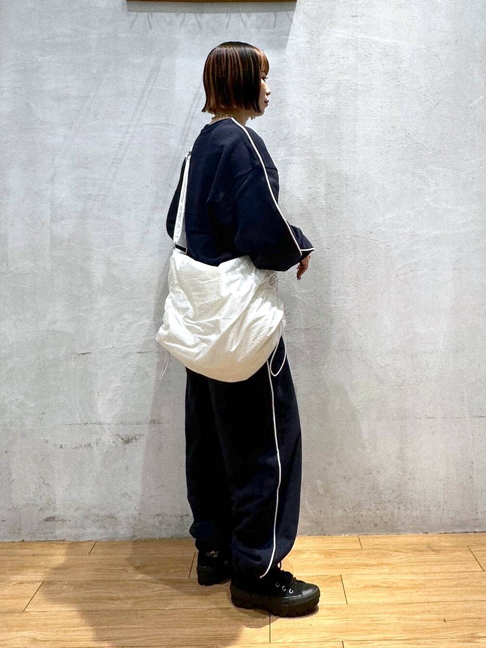 ホワイト系のショルダーバッグ、ブルー系のスウェットを着用したレディースの秋コーディネートの3枚目の写真