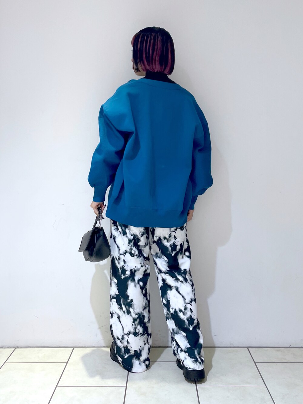 ブラック系のニット/セーター、ブルー系のカーディガン/ボレロ、ブラック系のショルダーバッグを着用したレディースの秋コーディネートの3枚目の写真