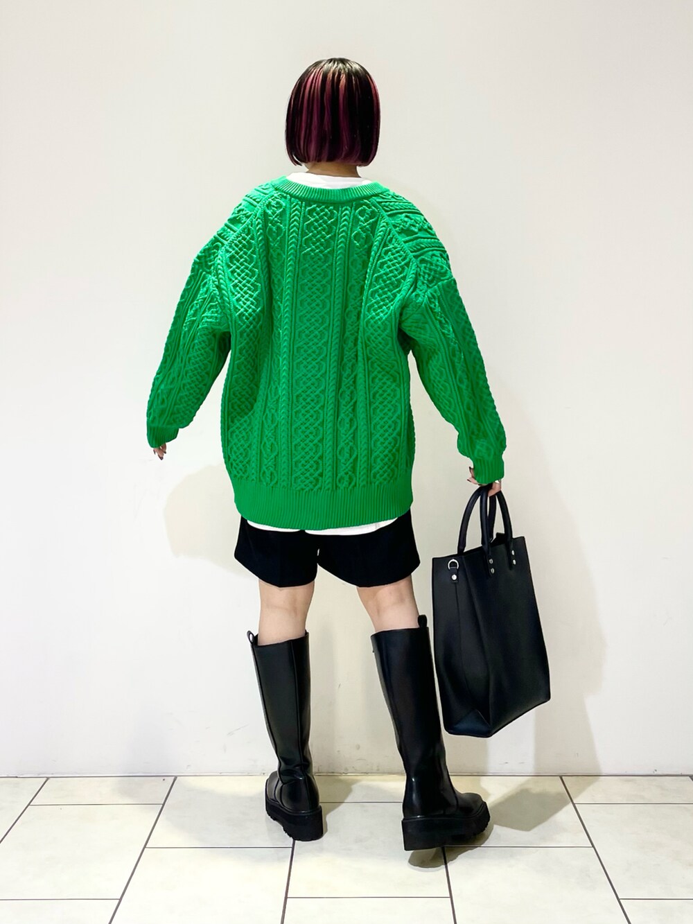 ホワイト系のTシャツ/カットソー、グリーン系のニット/セーター、ブラック系のトートバッグを着用したレディースの冬コーディネートの4枚目の写真