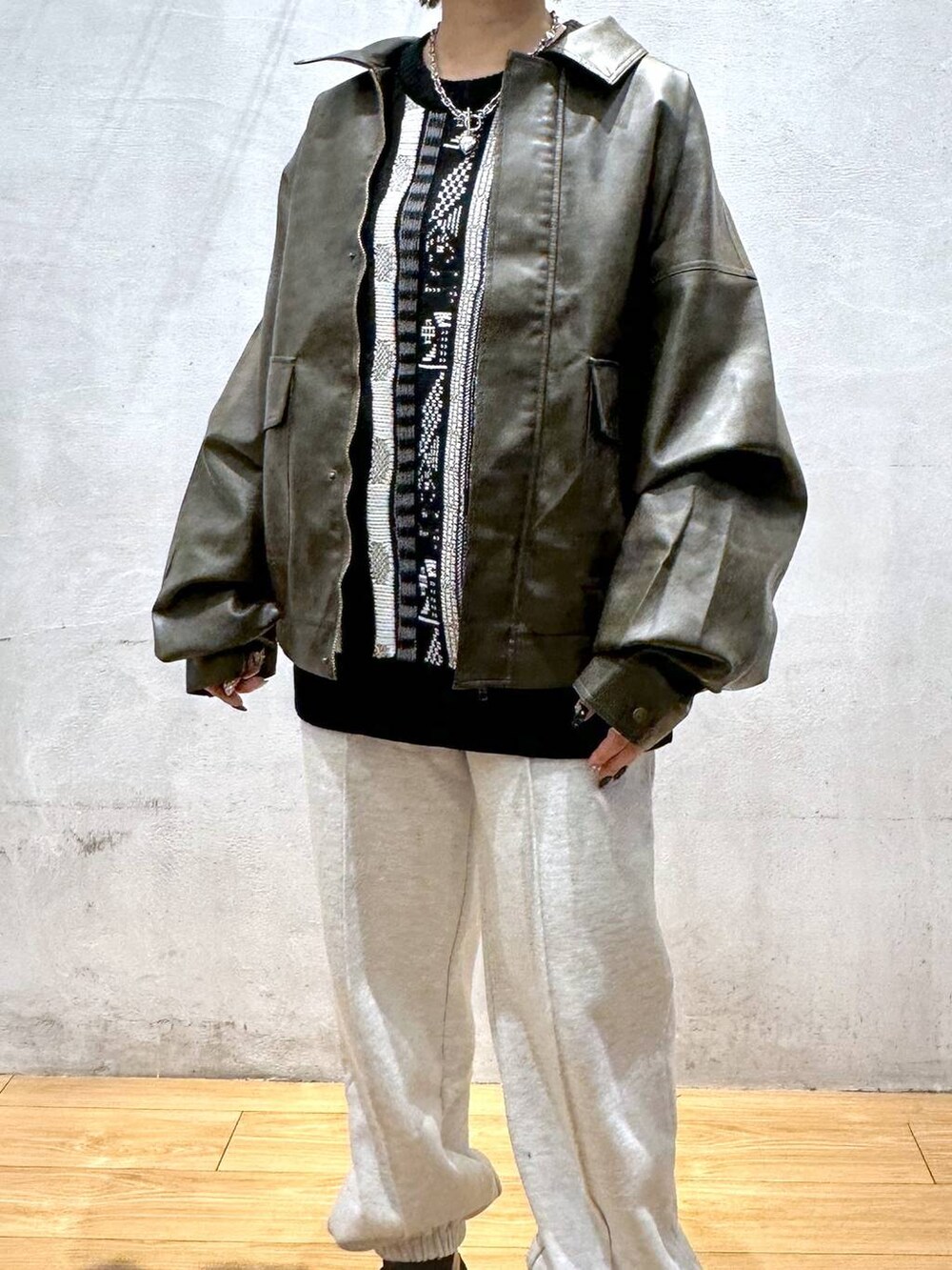 ブラウン系のブルゾン、グレー系のスウェットパンツ、ブラック系のニット/セーターを着用したレディースの秋コーディネートの6枚目の写真