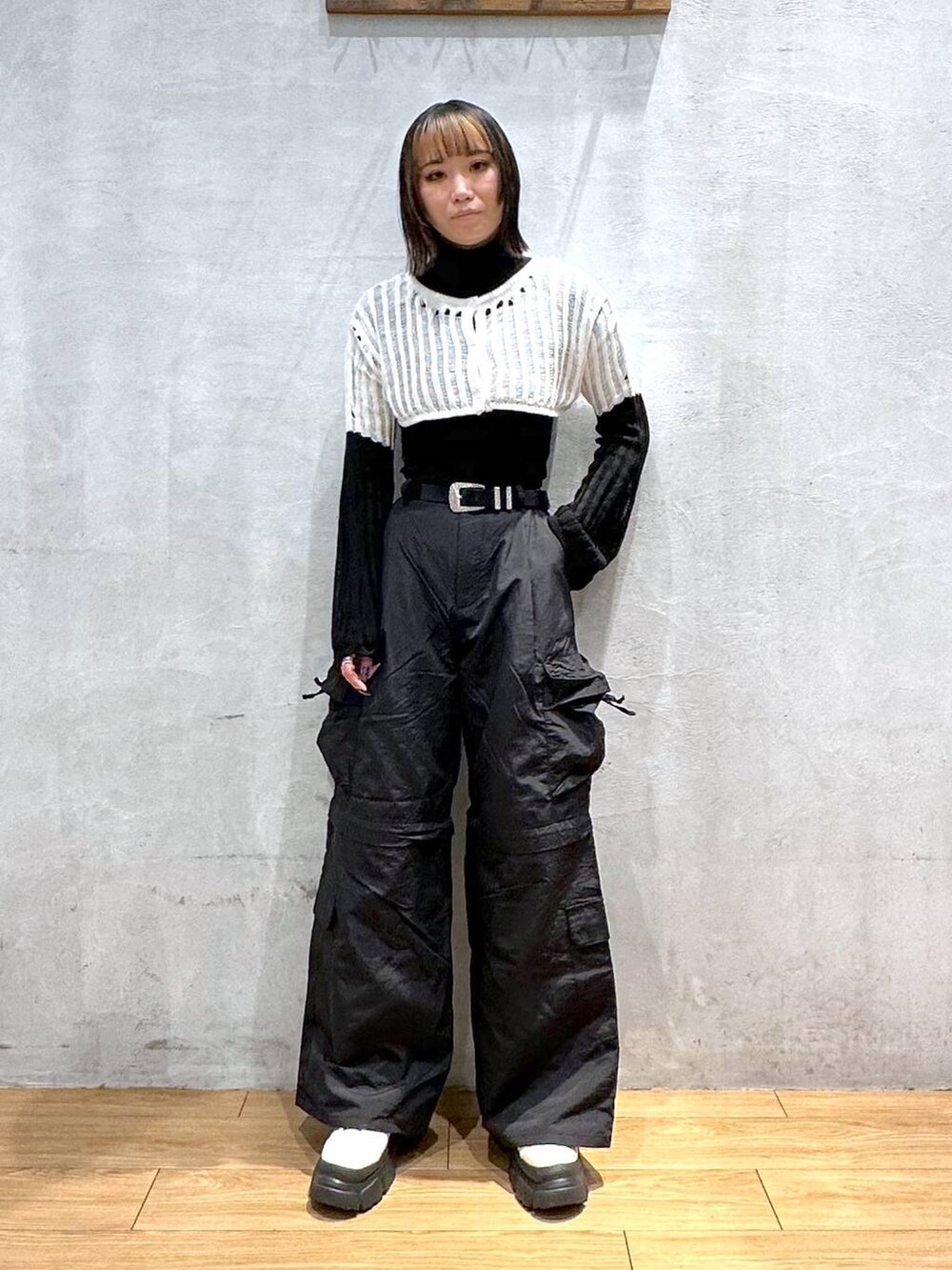 ホワイト系のニット/セーター、ブラック系のカーゴパンツ、ホワイト系のブーツを着用したレディースの冬コーディネートの2枚目の写真