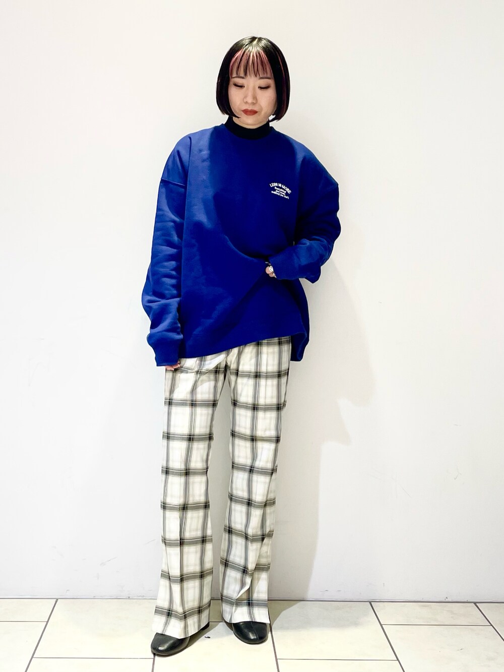 ブラック系のニット/セーター、ホワイト系のその他パンツ、ブラック系のブーツを着用したレディースの冬コーディネートの2枚目の写真