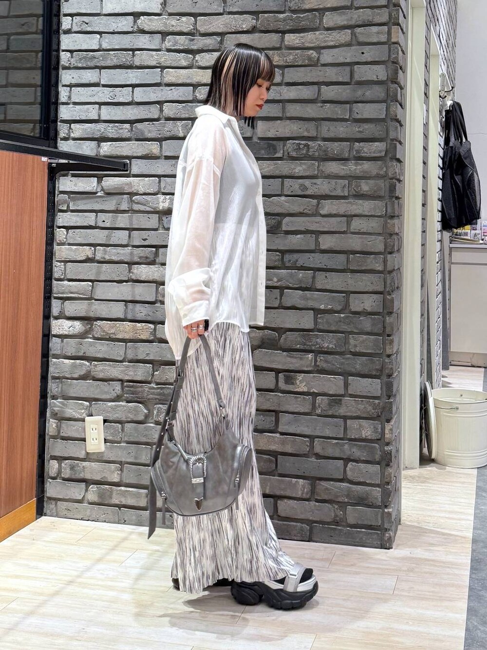 グレー系のサンダル、グレー系のショルダーバッグ、ブラック系のタンクトップを着用したレディースの春コーディネートの4枚目の写真