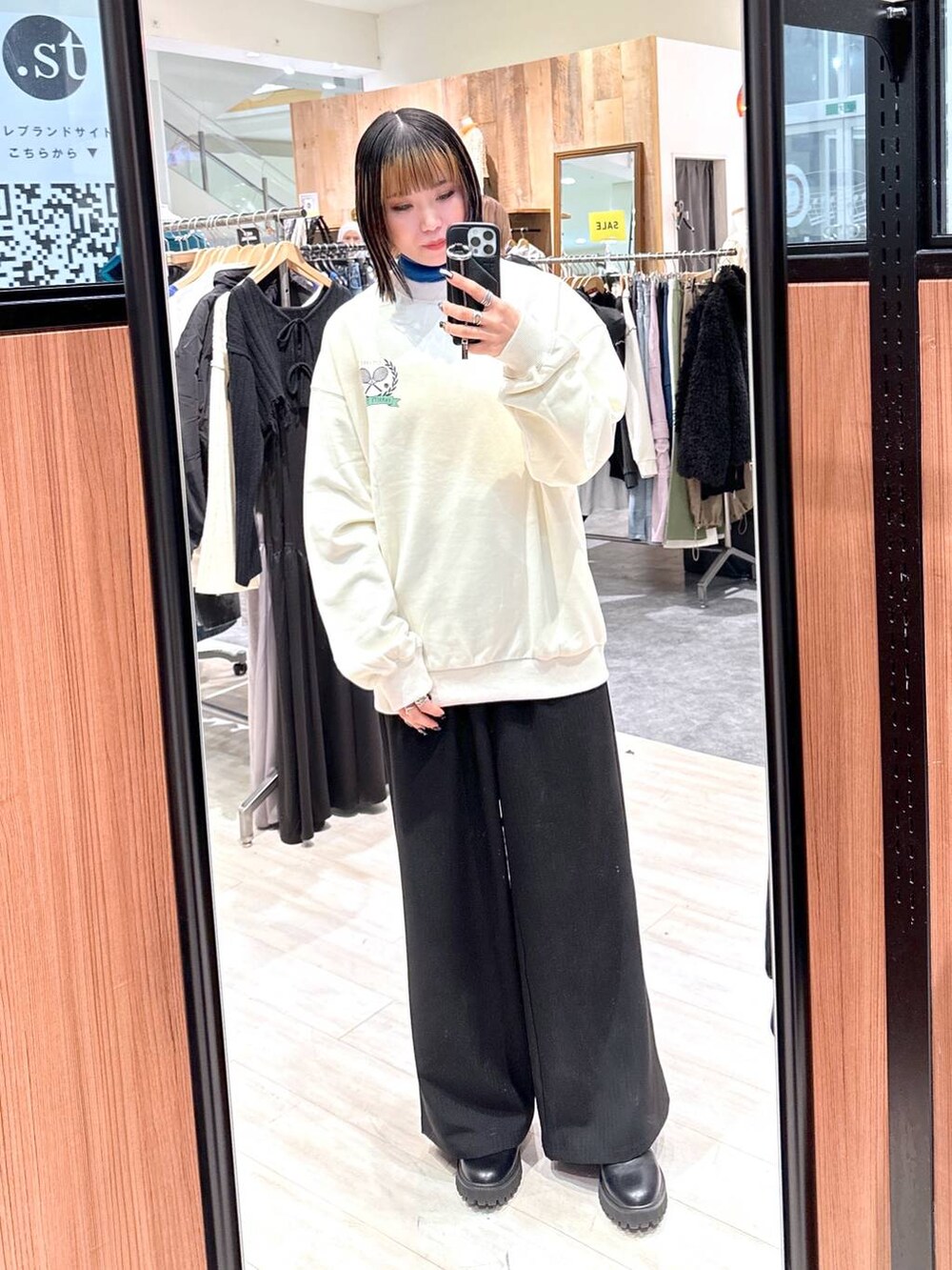 ブラック系のスラックス、ベージュ系のスウェットを着用したレディースの冬コーディネートの2枚目の写真