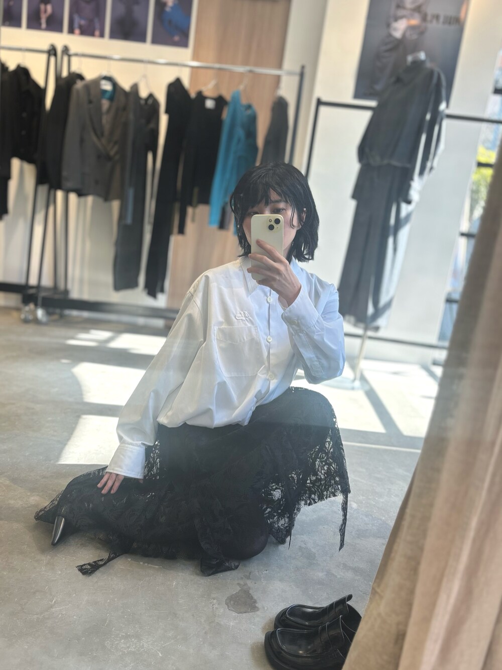 ブラック系のスカート、ホワイト系のシャツ/ブラウスを着用したレディースの秋コーディネートの2枚目の写真