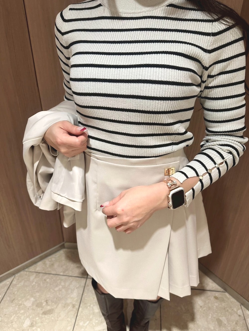 ホワイト系のニット/セーター、グレー系のテーラードジャケット、グレー系のスカートを着用したレディースの冬コーディネートの3枚目の写真