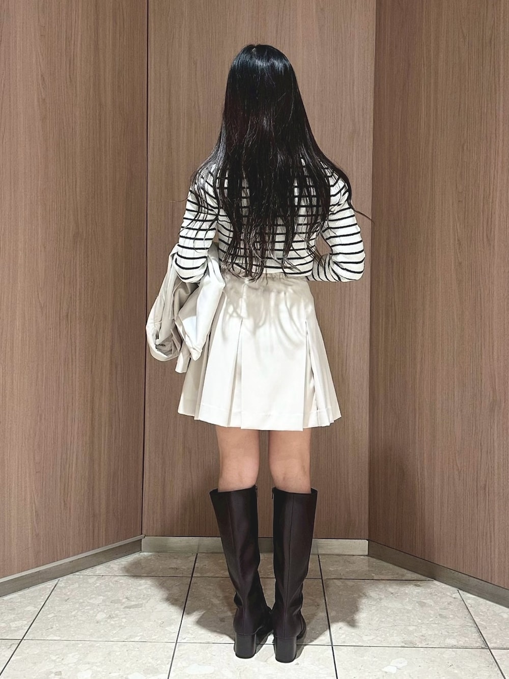 ホワイト系のニット/セーター、グレー系のテーラードジャケット、グレー系のスカートを着用したレディースの冬コーディネートの2枚目の写真