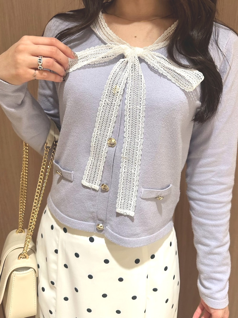 ホワイト系のショルダーバッグ、ブルー系のニット/セーター、ホワイト系のスカートを着用したレディースの冬コーディネートの3枚目の写真