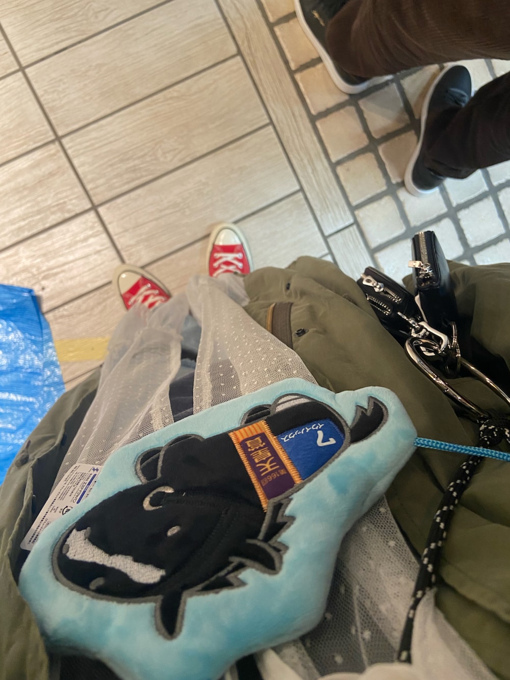 ホワイト系のワンピース、グリーン系のモッズコート、ブルー系のデニムパンツを着用したレディースの秋コーディネートの2枚目の写真